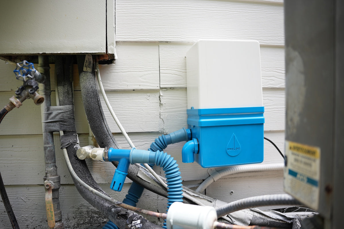 Production Unclog system installed beside residential A/C equipment and condensate piping