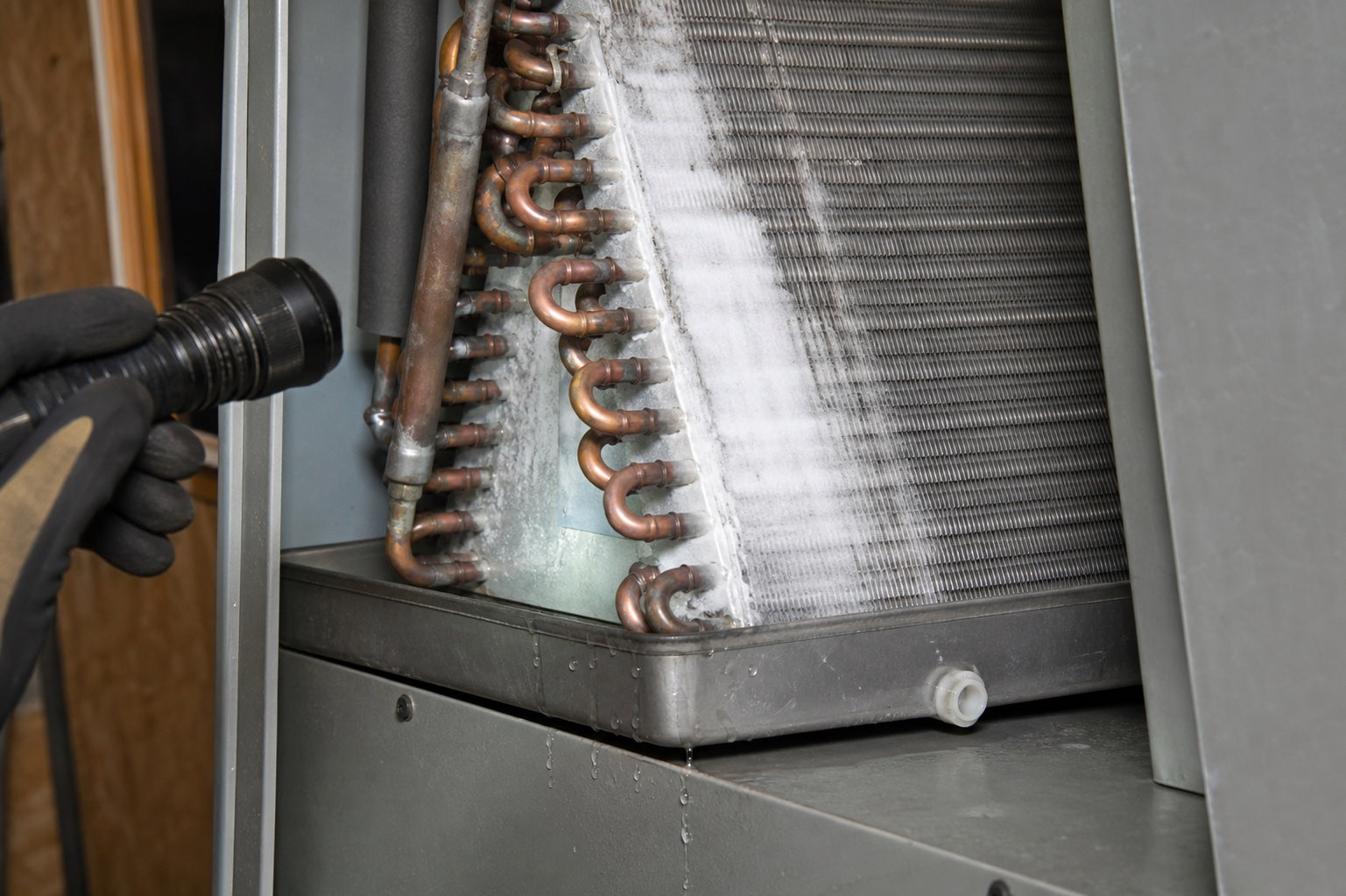 Frost and ice on a residential evaporator coil above the condensate pan